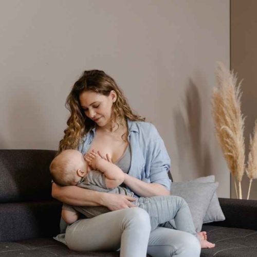 mother breastfeeding child on couch