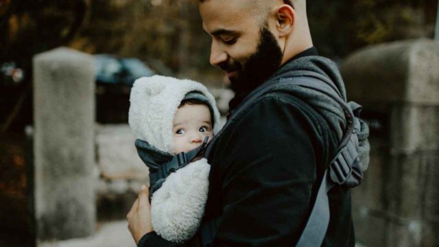 dad carrying baby in inward facing baby carrier