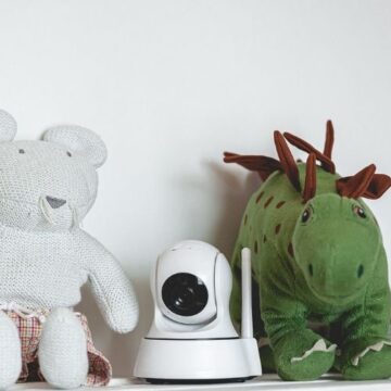 Video baby monitor with remote pan, tilt, and zoom on a shelf with toys.