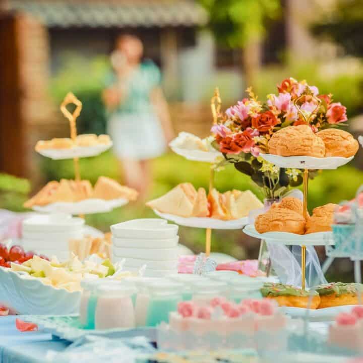 best baby shower venues table with pastries, tea, and finger sandwhiches outdoors
