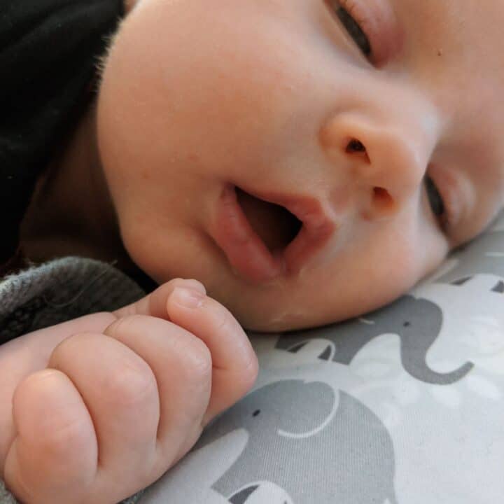 Milk drunk baby falling asleep on Boppy nursing pillow after breastfeeding.