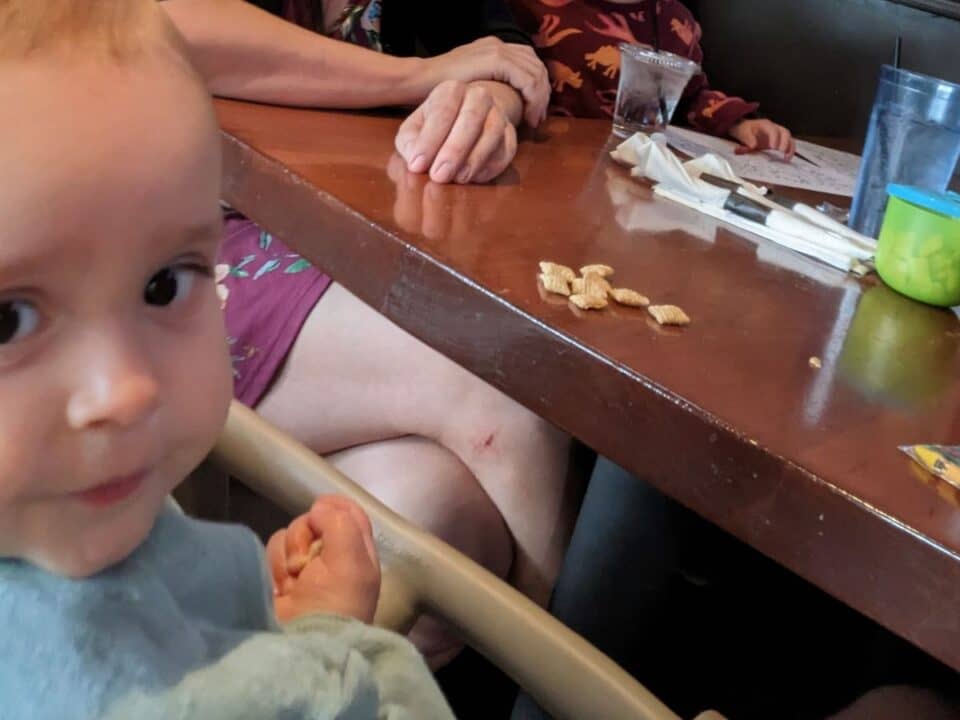 Baby eating at a high chair at a restaurant