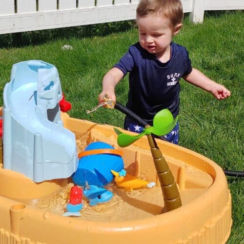 2-year-old boy playing with pirate cove water table