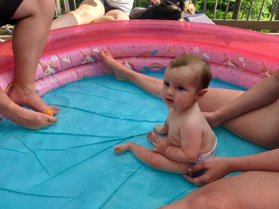 Toddler boy with parents in a blow up kiddie pool