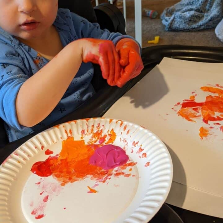 toddler boy playing with finger paints