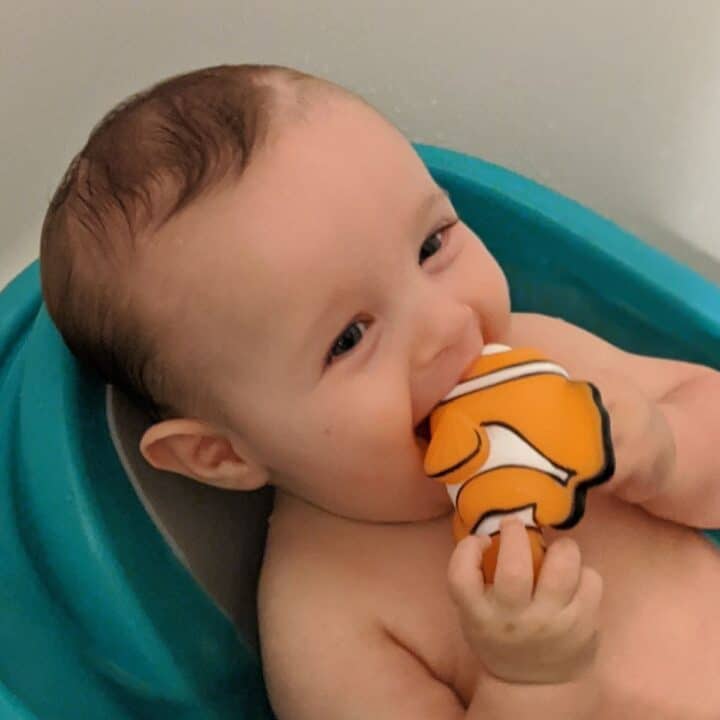 Baby playing in the bath with toy