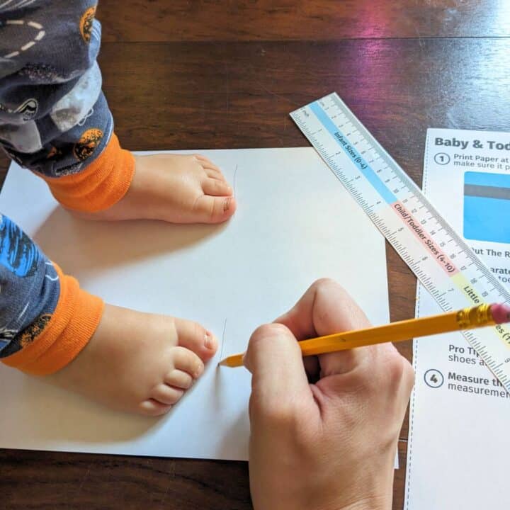 Mom marking her son's big toe on a sheet of paper with the cutout ruler from Mommy Maker Teacher. 