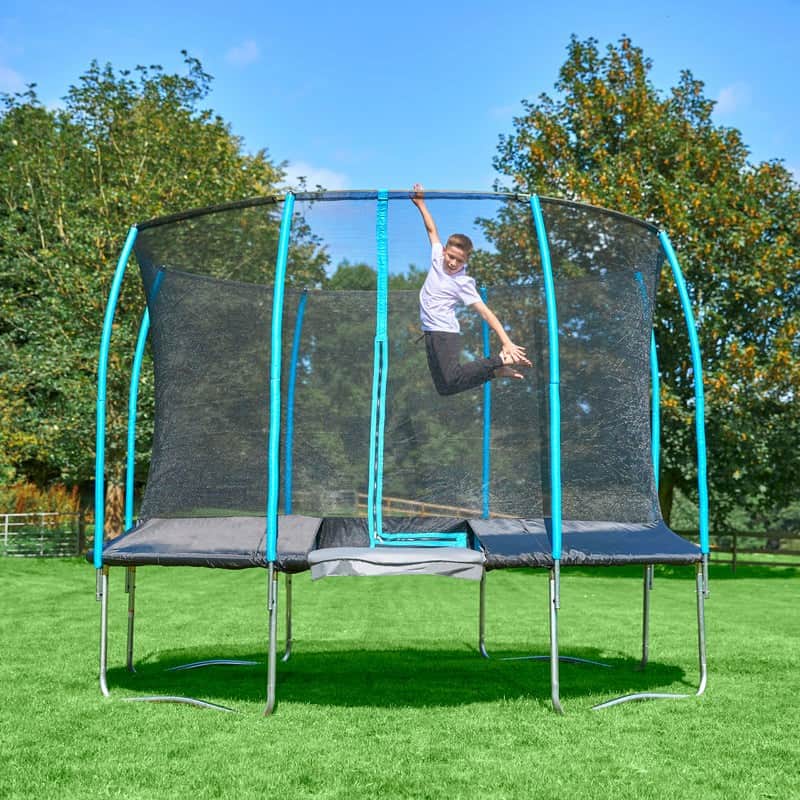 Boy jumping on an outdoor stand alone trampoline