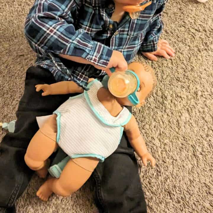 toddler feeding baby doll